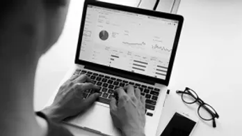 Image d'un logiciel d'entreprise sur un ordinateur, main sur le clavier : ERP / CRM