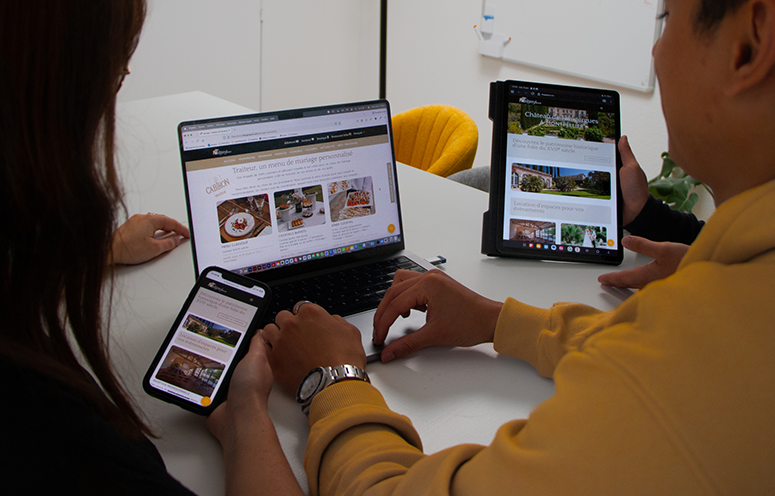 Équipe consultant une solution web multi-supports sur ordinateur portable, tablette et smartphone, illustrant l'accessibilité sur différents appareils.